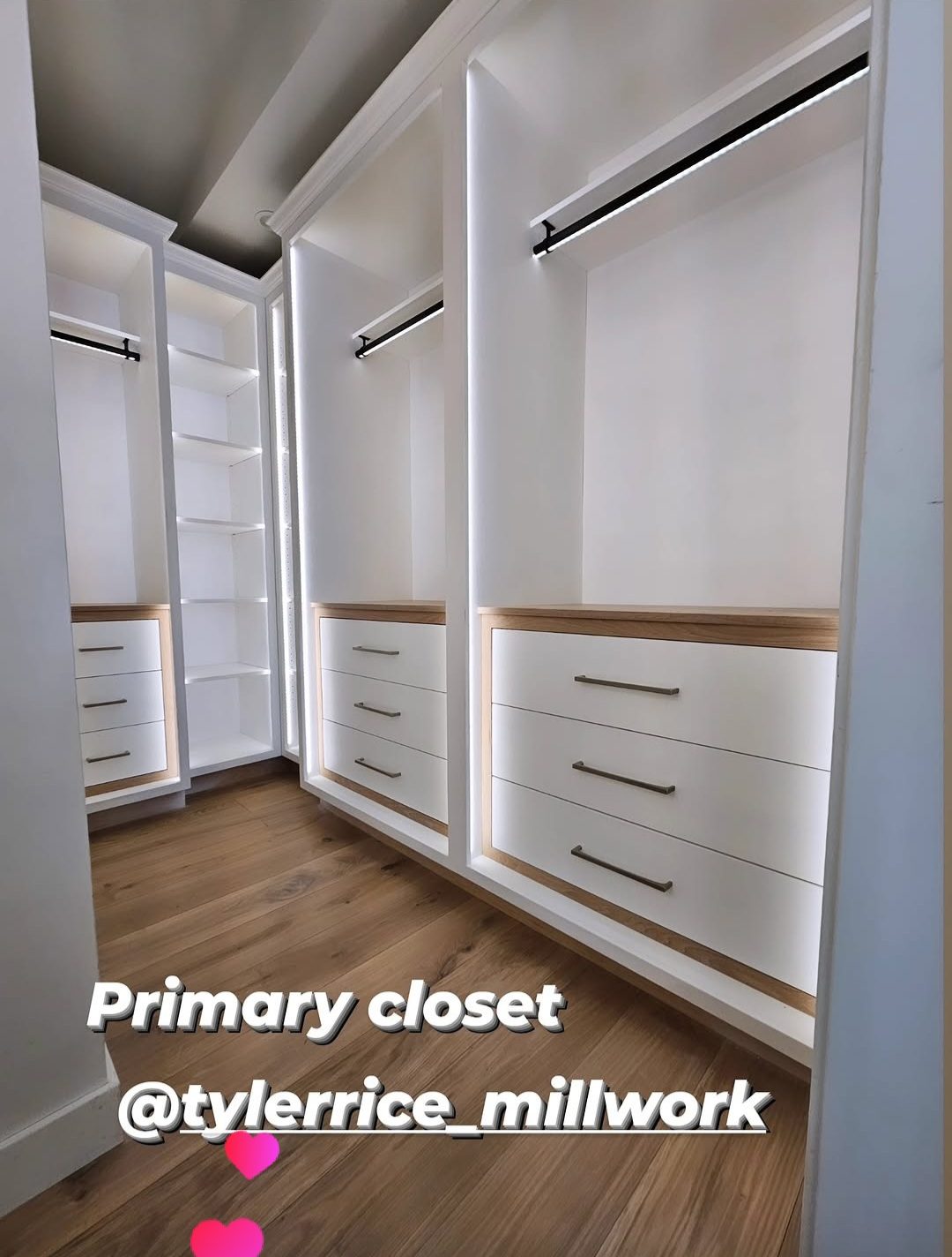 Custom primary closet system built by TR Millwork, with lit shelving, hanging space, and drawers